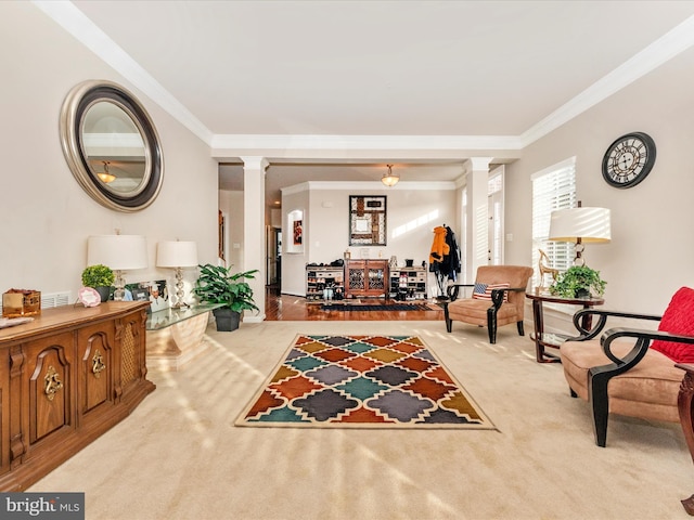 sitting room with light carpet, decorative columns, and crown molding