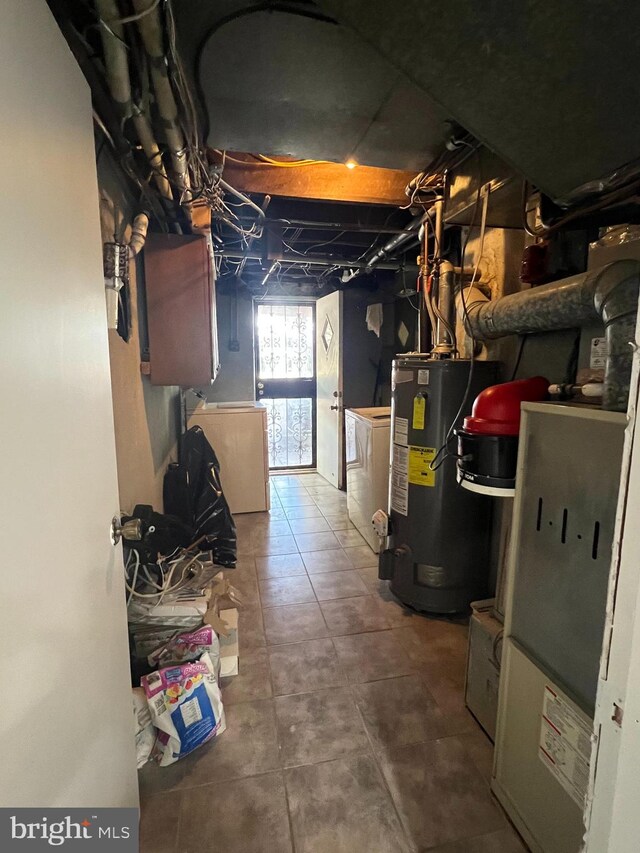 basement with gas water heater, heating unit, and washer / clothes dryer