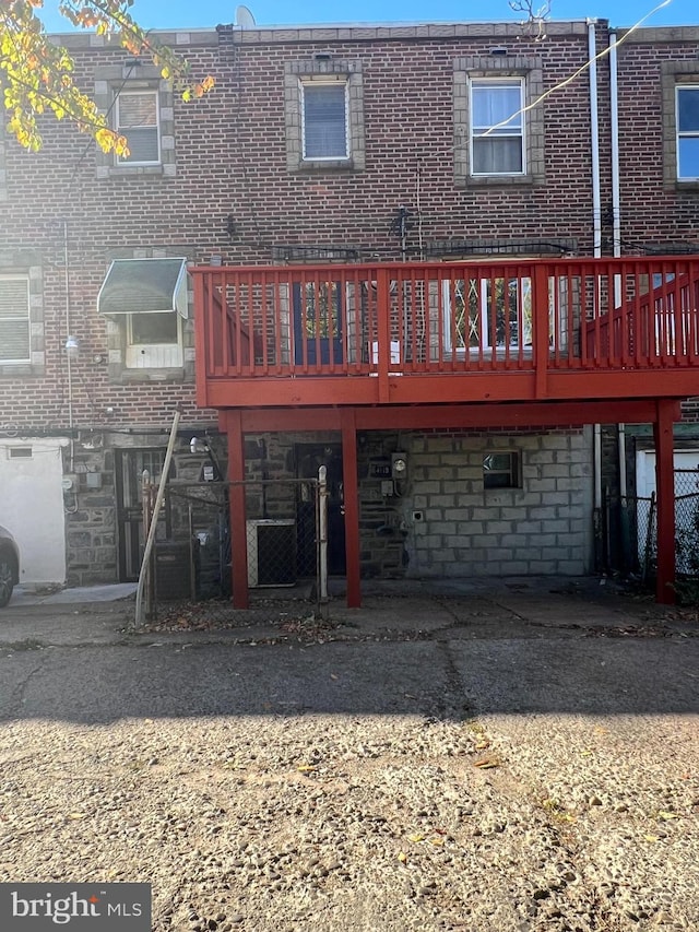 back of property with a wooden deck and brick siding