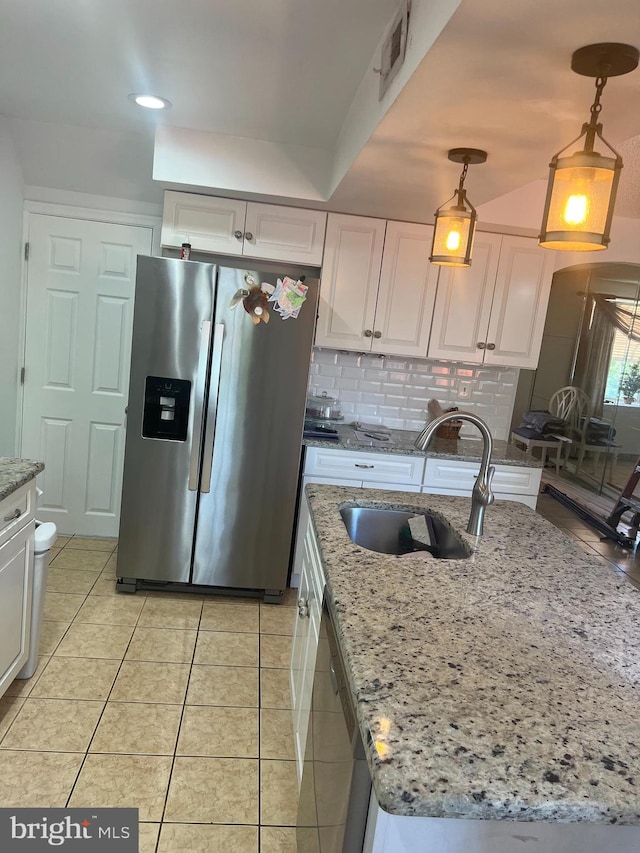 kitchen featuring light stone counters, white cabinetry, stainless steel appliances, sink, and decorative light fixtures