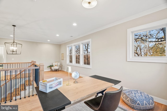 dining space featuring a chandelier, hardwood / wood-style floors, a healthy amount of sunlight, and ornamental molding