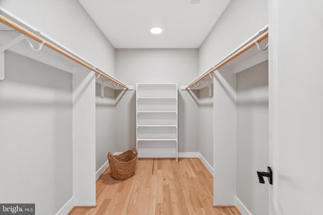 walk in closet with hardwood / wood-style floors