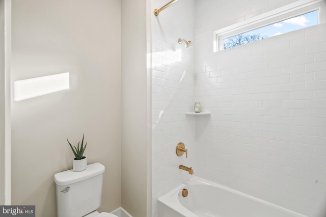 bathroom with tiled shower / bath combo and toilet