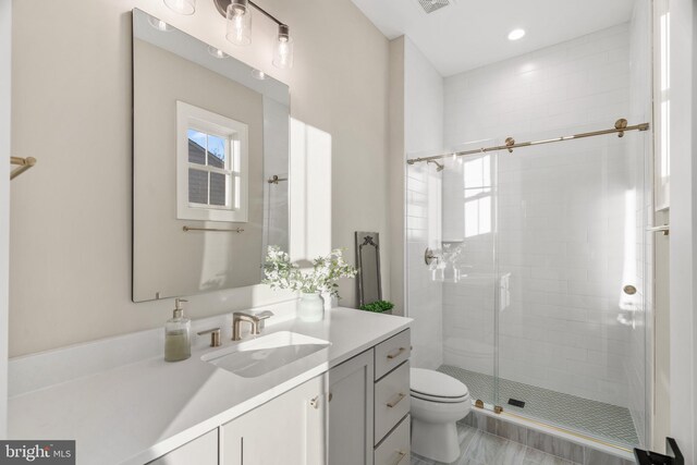 bathroom featuring an enclosed shower, vanity, and toilet