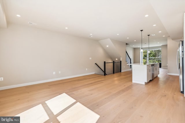 kitchen featuring white cabinetry, light wood-type flooring, a center island, stainless steel appliances, and decorative light fixtures