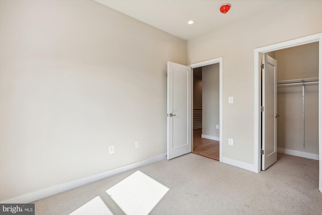 unfurnished bedroom featuring light carpet and a closet