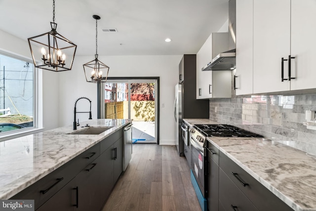 kitchen featuring plenty of natural light, hanging light fixtures, sink, white cabinetry, and appliances with stainless steel finishes