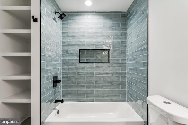 bathroom with toilet, built in features, and tiled shower / bath combo