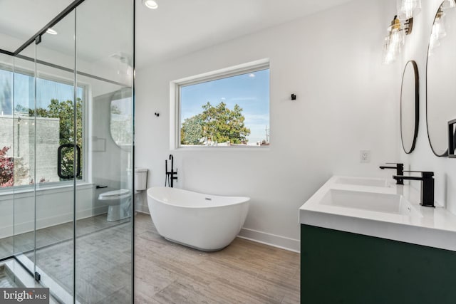 full bathroom featuring separate shower and tub, vanity, hardwood / wood-style flooring, and toilet