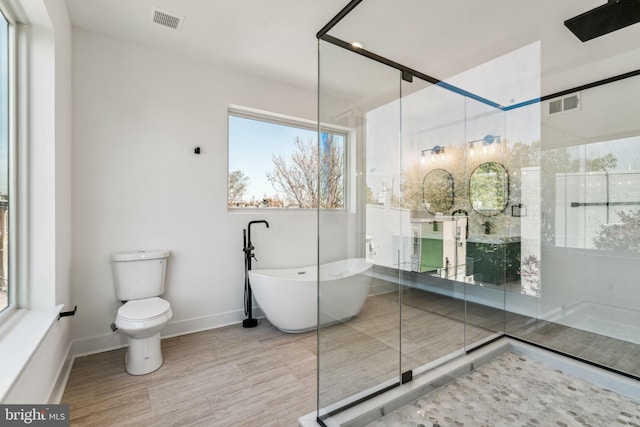 bathroom with wood-type flooring, toilet, and plus walk in shower