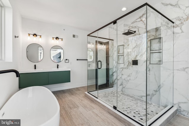 bathroom featuring vanity, hardwood / wood-style flooring, and separate shower and tub