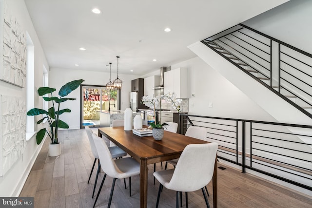 dining area with wood-type flooring and a chandelier