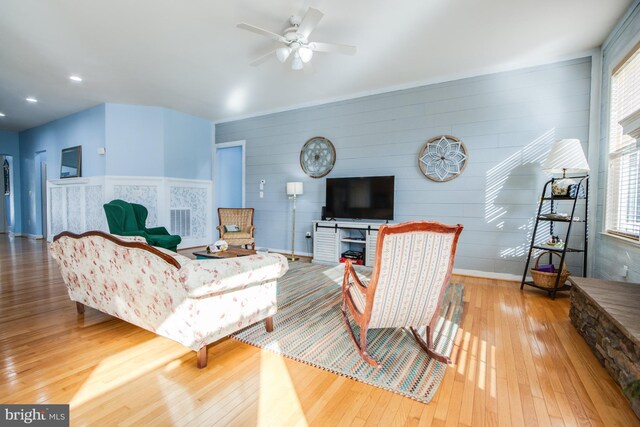 living room with light hardwood / wood-style floors and ceiling fan