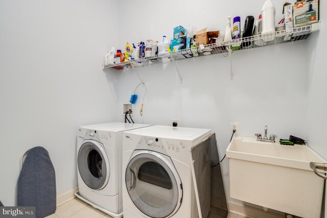 laundry room with independent washer and dryer, light tile patterned flooring, and sink