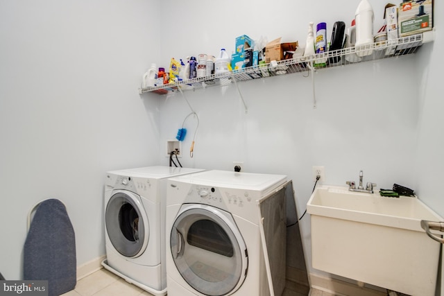 washroom featuring a sink, laundry area, light tile patterned flooring, and independent washer and dryer
