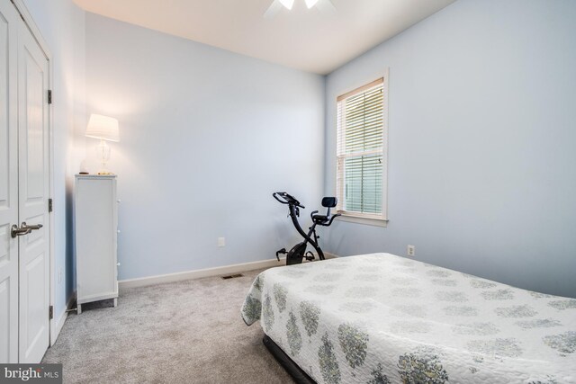 bedroom featuring a closet, ceiling fan, and light colored carpet