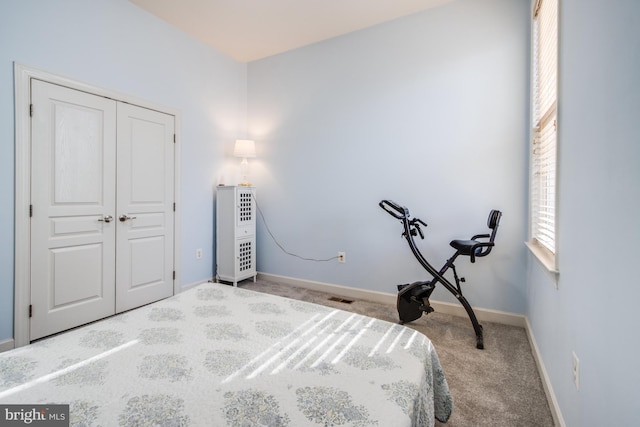 bedroom featuring carpet flooring, a closet, visible vents, and baseboards