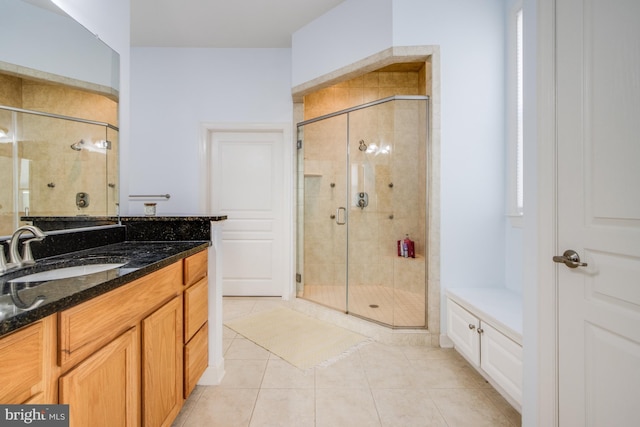 bathroom with tile patterned floors, vanity, and a shower stall