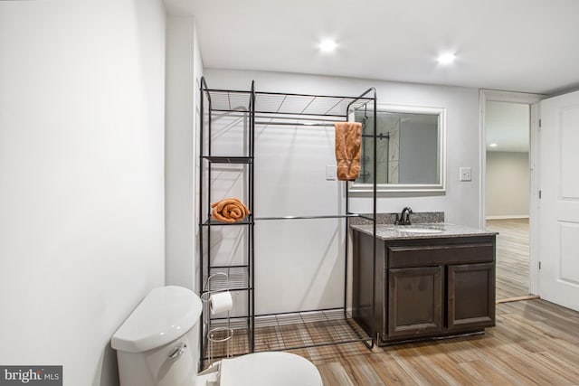 bathroom with toilet, vanity, recessed lighting, and wood finished floors