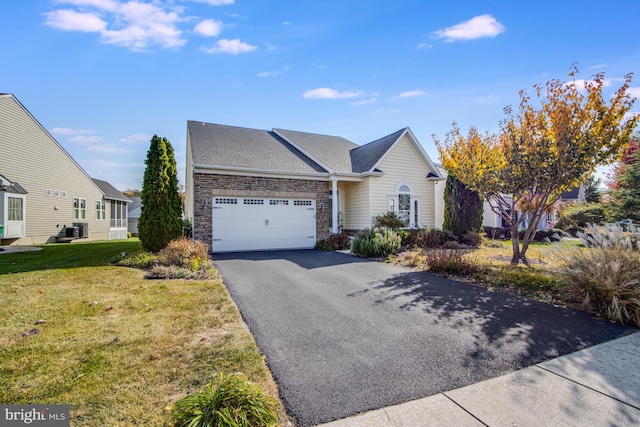 ranch-style home with central air condition unit, stone siding, driveway, a garage, and a front yard