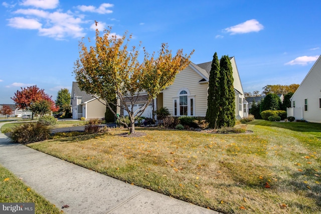 view of property hidden behind natural elements featuring a front yard