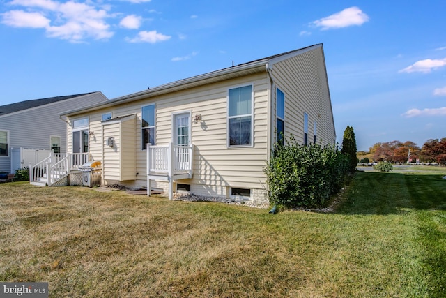 rear view of house featuring a yard