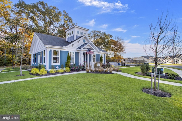 view of front of home with a front lawn and roof with shingles