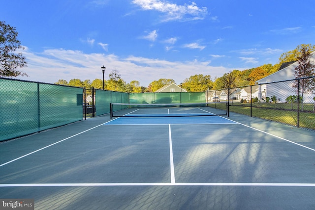 view of tennis court featuring fence