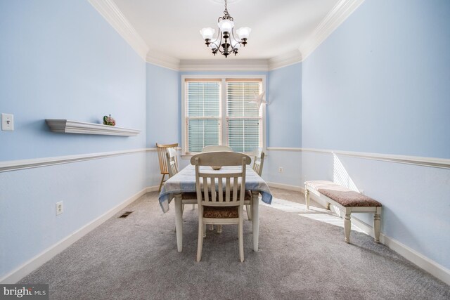 carpeted dining space with crown molding, a chandelier, and baseboards