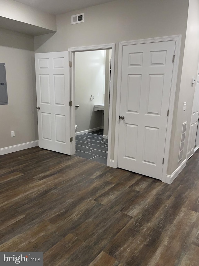 interior space featuring electric panel and dark hardwood / wood-style floors