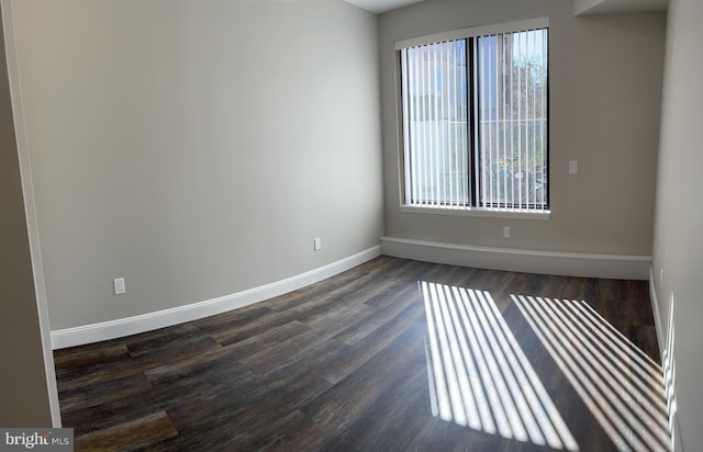 spare room with a healthy amount of sunlight and dark hardwood / wood-style flooring