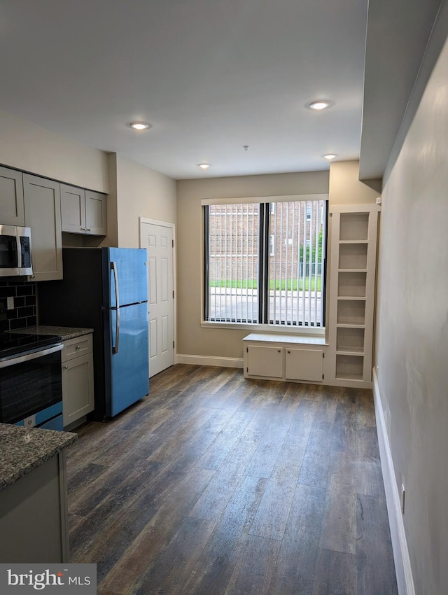 kitchen featuring appliances with stainless steel finishes, tasteful backsplash, gray cabinets, and dark hardwood / wood-style flooring