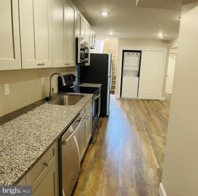 kitchen featuring light stone countertops, sink, dark hardwood / wood-style flooring, white cabinetry, and stainless steel appliances