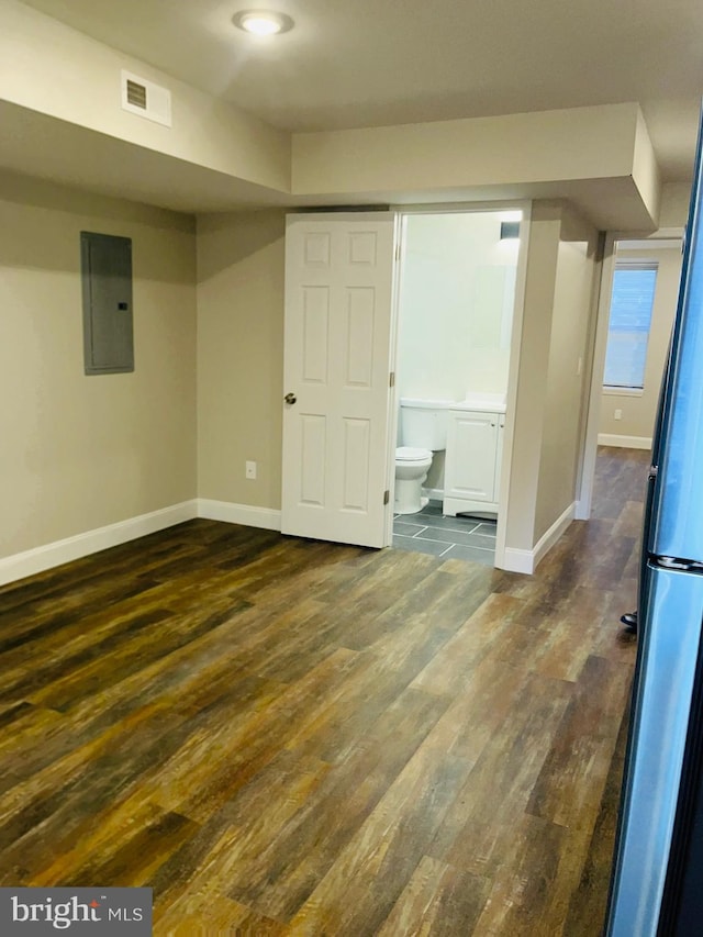 interior space with electric panel, dark wood-type flooring, and stainless steel refrigerator