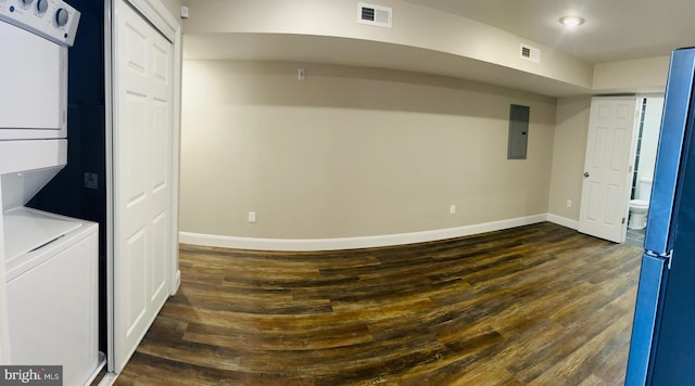 basement with stacked washing maching and dryer, electric panel, and dark wood-type flooring