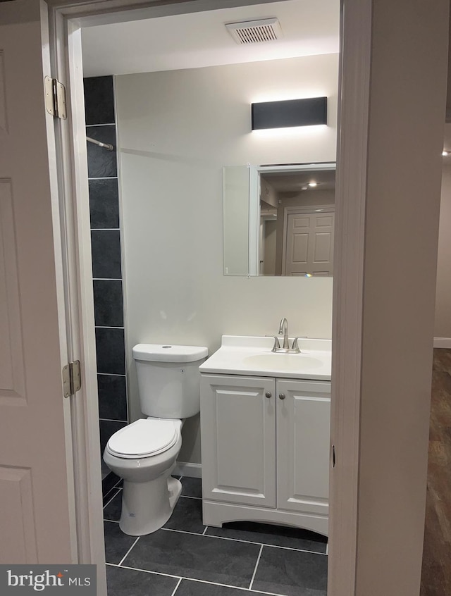 bathroom featuring toilet, vanity, and tile patterned floors