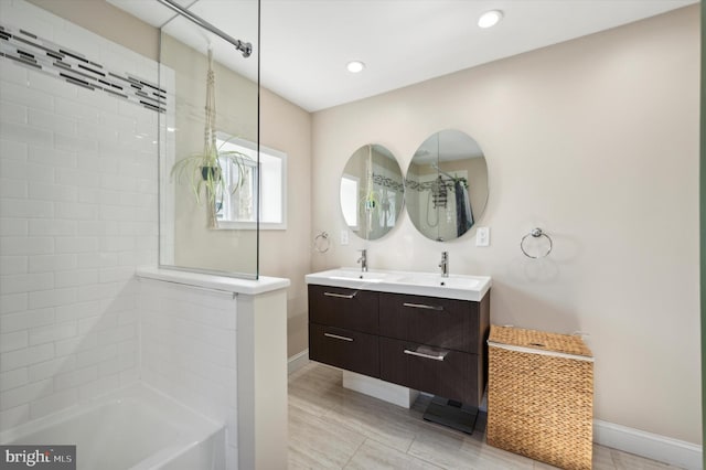 bathroom with tiled shower / bath combo, hardwood / wood-style flooring, and vanity