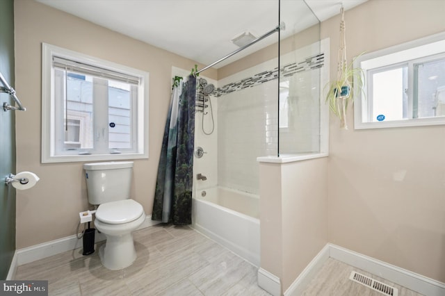 bathroom featuring shower / bath combo with shower curtain and toilet