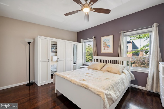 bedroom featuring dark hardwood / wood-style floors, multiple windows, and ceiling fan