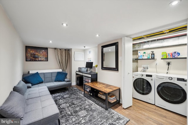 living room featuring washer and clothes dryer and light hardwood / wood-style flooring