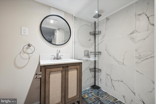 bathroom featuring ornamental molding, a tile shower, and vanity