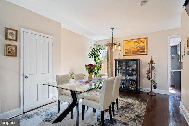 dining space featuring a notable chandelier and dark hardwood / wood-style floors