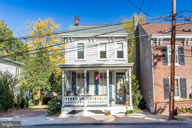 italianate house with a chimney and a porch