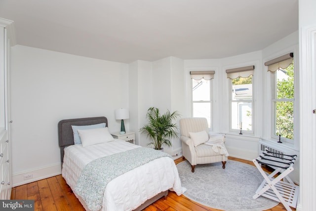 bedroom featuring hardwood / wood-style flooring and baseboards