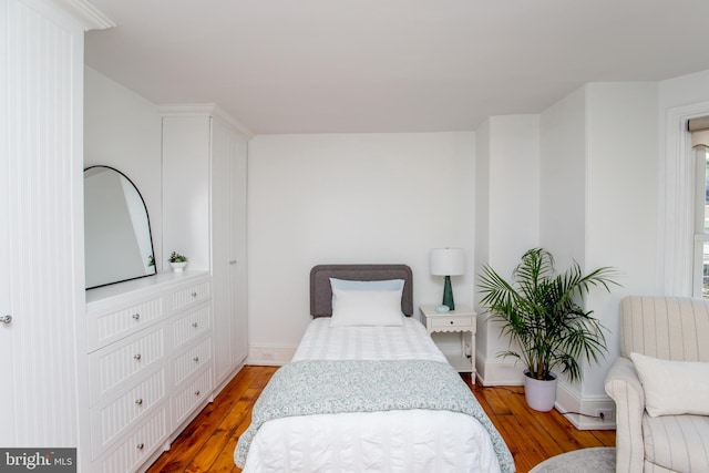 bedroom with baseboards and wood finished floors