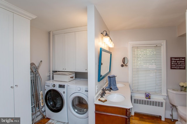 laundry area with a sink, separate washer and dryer, light wood-type flooring, radiator, and laundry area
