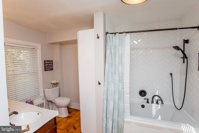 full bath with shower / tub combo, wood finished floors, vanity, and toilet