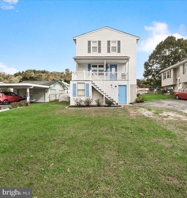 back of house featuring a carport, a lawn, and a porch