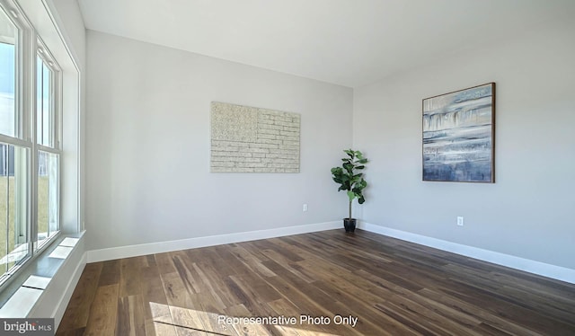 empty room with dark hardwood / wood-style flooring