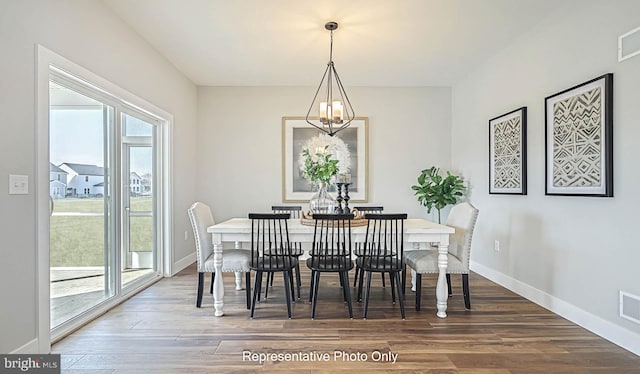 dining area with hardwood / wood-style flooring, a wealth of natural light, and a chandelier